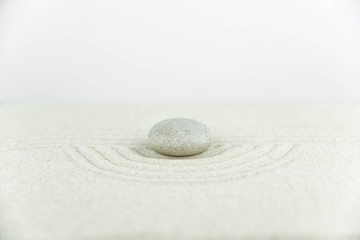 Zen garden. Pyramids of white and gray zen stones on the white sand with abstract wave drawings. Concept of harmony, balance and meditation, spa, massage, relax.