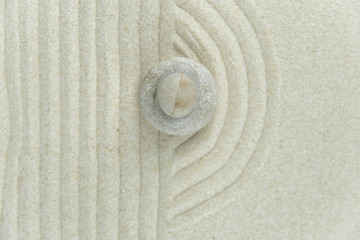 Zen garden. Pyramids of white and gray zen stones on the white sand with abstract wave drawings. Concept of harmony, balance and meditation, spa, massage, relax.