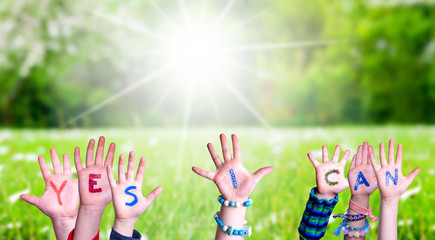 Children Hands Building Colorful Word Yes I Can. Green Grass Meadow As Background