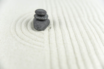 Zen garden. Pyramids of white and gray zen stones on the white sand with abstract wave drawings. Concept of harmony, balance and meditation, spa, massage, relax.