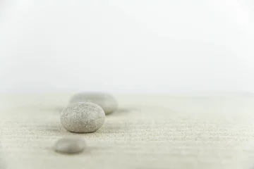 Foto op Canvas Zentuin. Piramides van witte en grijze zenstenen op het witte zand met abstracte golftekeningen. Concept van harmonie, balans en meditatie, spa, massage, ontspannen. © strigana