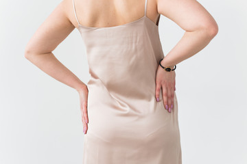 Fashion photo of young lady in elegant evening dress on white background, close-up back view.