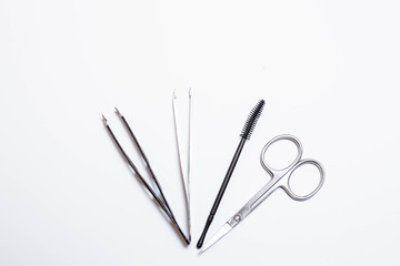 Makeup brushes, scissors, tweezers, mascara on a white background. Makeup. Beauty and fashion.