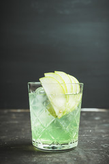 Green apple beverage on the rustic background. Selective focus.