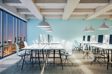 Modern office interior hall with computers and night city view.