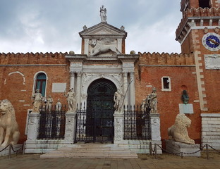 The entrance to the Venice arsenal with a forged door and two statues of lions