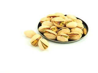 Pistachios in a round dish isolated on a white background. High Vitamin B6 and antioxidants. Low in calories yet high in protein..
