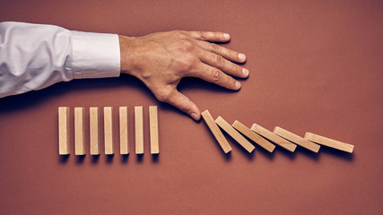 Fototapeta Męska dłoń i drewniane klocki ułożone w konceptualnym wizerunku obraz
