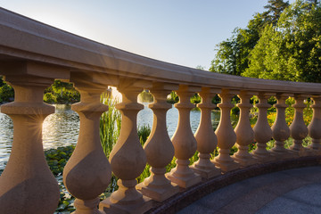 Fragment of stone balustrade over the decorative pond at sunset
