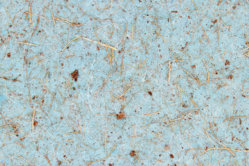 Blue paper cardboard with a rough coarse texture and wood chips. Abstract background.