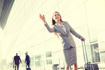 Fototapeta premium Cutout of Young attractive businesswoman calling taxi in airport 