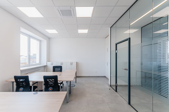 Interior of small new empty office space with desks and chairs