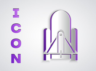 Paper cut Rocket launch from the spaceport icon isolated on grey background. Launch rocket in space. Paper art style. Vector Illustration