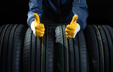 Good new tires concept with a service man fingers up - obrazy, fototapety, plakaty