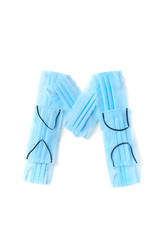 Letter M made from protective medical masks on a white background.