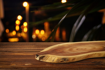 background Image of wooden table in front of abstract blurred restaurant lights
