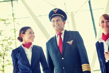 Mature pilot walking with beautiful stewardess in airport © MDBPIXS