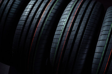 Set of new tires on a black background - obrazy, fototapety, plakaty