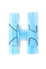 Letter H made from protective medical masks on a white background.