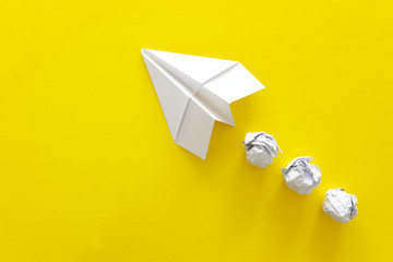 education or innovation concept. paper origami plane over yellow background