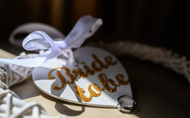 Engagement or wedding ring and bride to be wedding decorations on a wooden table.