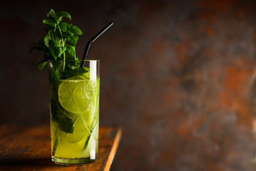 Mojito cocktail with lime and mint on the rustic background. Selective focus. Shallow depth of field.
