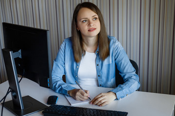 Girl works at the computer at home. She is a photographer. Retouch is her hobby. She is self...