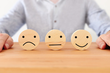 Concept image of satisfaction level. wooden circles with emotions