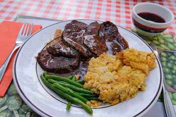 Typical authentic Brasato, beef stew, with polenta and a famous ceramic boccalino mug, Ticino, Switzerland