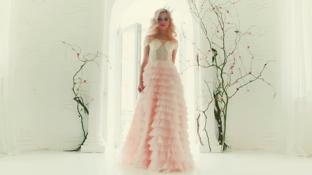 Beautiful blonde woman queen open balcony. Lady princess enjoy white room 