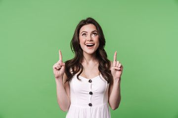 Image of happy caucasian woman smiling and pointing fingers upward