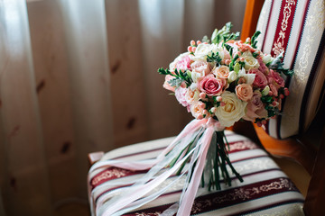 Beautiful wedding bouquet on chair. White, pink tender roses.