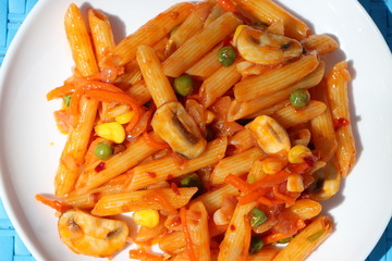 Penne pasta in tomato sauce with peas, button mushrooms, tomatoes and vegetables, Red mushroom wholegrain pasta