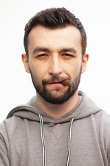 Obraz premium Handsome stylish man smokes a cigar.