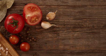A nice home-made still life of vegetables and seasonings on a natural wooden background with space for text.