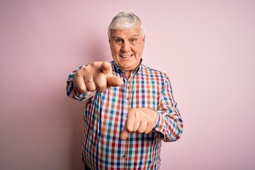 Senior handsome hoary man wearing casual colorful shirt over isolated pink background pointing to you and the camera with fingers, smiling positive and cheerful