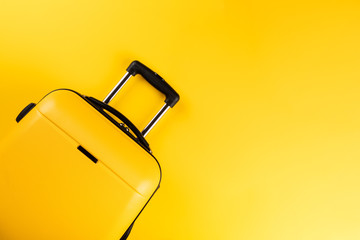 Yellow suitcase on a yellow background.Travel concept.Holiday Adventure Trip.