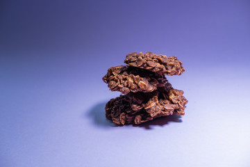 Oatmeal and chocolate cookies isolated on purple background. Healthy snack. Close up view.