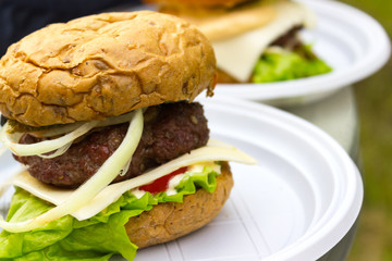 appetizing fresh homemade burger with meat, cheese and lettuce on a wooden table. Delicious fast food concept.  hamburger day cancelled