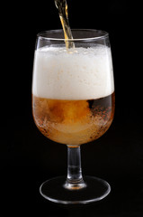 Remplir un verre de bière blonde sur fond noir