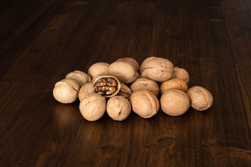 Nuts on a wooden table top of boards with a dark textured surface.