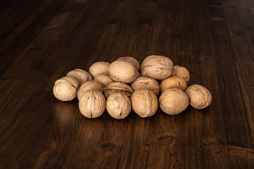 Nuts on a wooden table top of boards with a dark textured surface.
