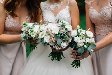 Wedding bouquets in the hands of the bride and bridesmaids
