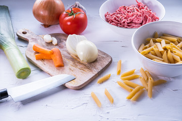 Ingredients to prepare pasta bolognese on white background. Food from Italy. Healthy cuisine.