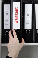 Wartezeit – Finanzen/Statistik. Ordner im Büro-Regal. Hand greift Unterlagen im Schrank....