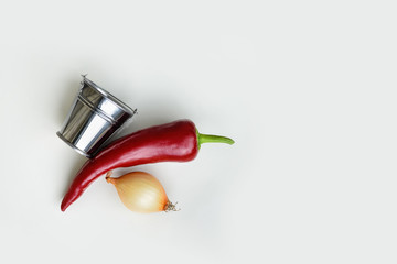 on a white background, a bucket,red pepper and onion