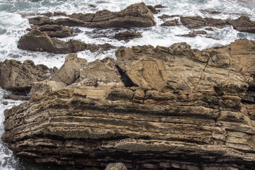 Sea coast. Rocky terrain. A beach off the coast of Zumaya. The nature of Spain. The natural wealth of Europe. Geological phenomenon. Layers of rock.