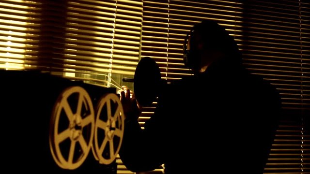 The special agent overhears the conversation with a directional microphone and records it on a tape recorder, selective focus.