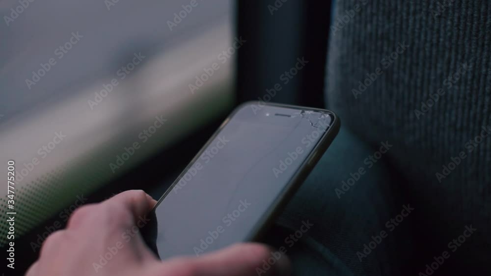 Poster closeup of a smartphone in the hands of a man in a public transport bus. moving glare and shadows ar