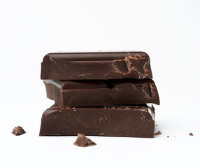 stack of pieces of black chocolate on a white background